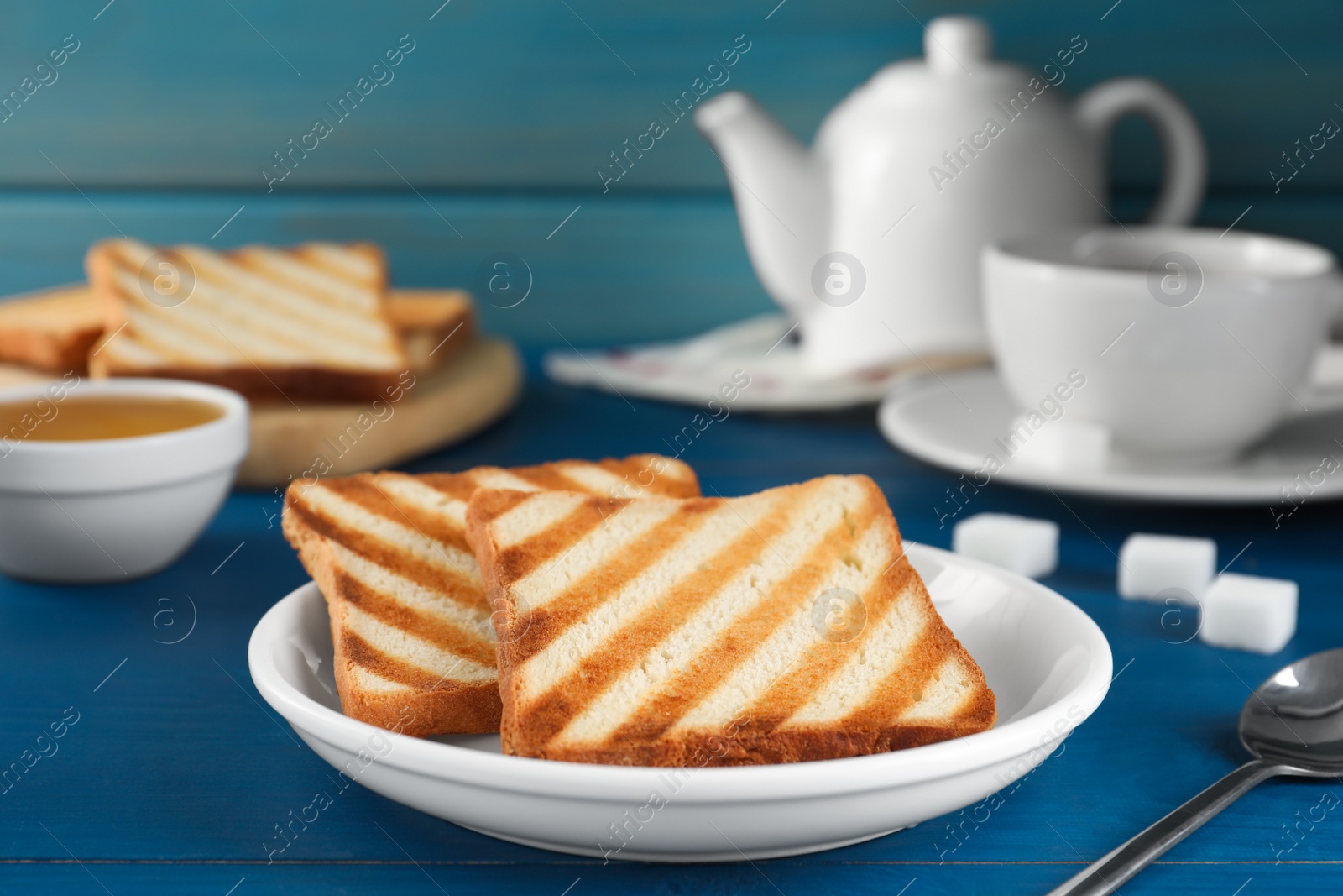 Photo of Slices of tasty toasted bread on blue wooden table