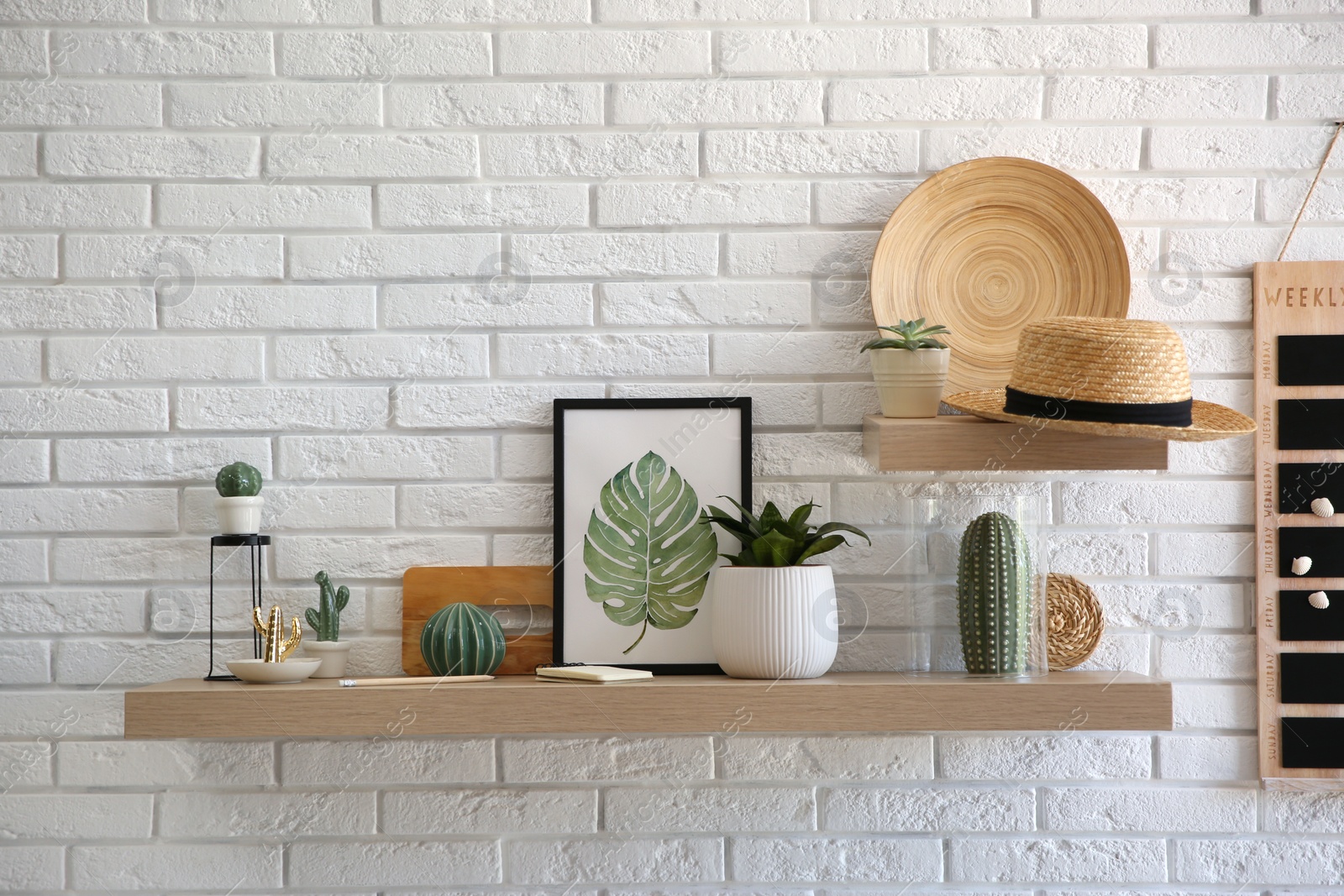 Photo of Shelves with decorative elements on white brick wall. Interior design