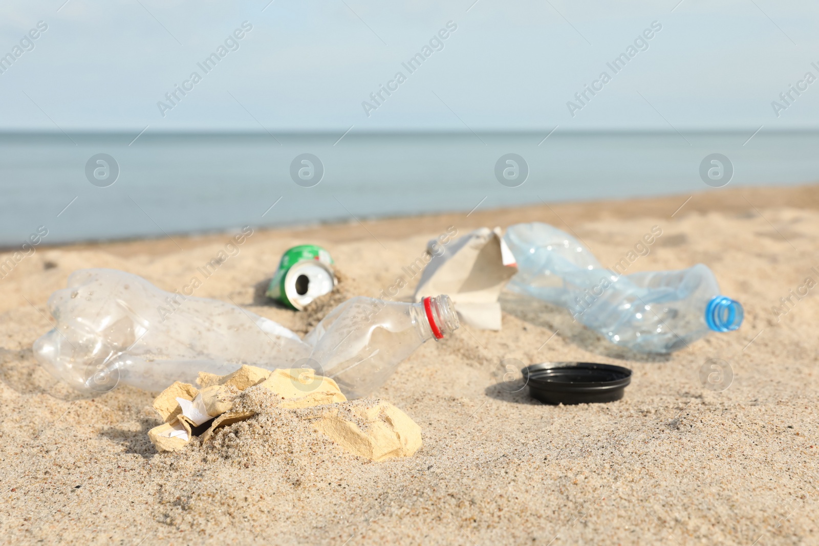 Photo of Garbage scattered on beach near sea, closeup. Recycling problem