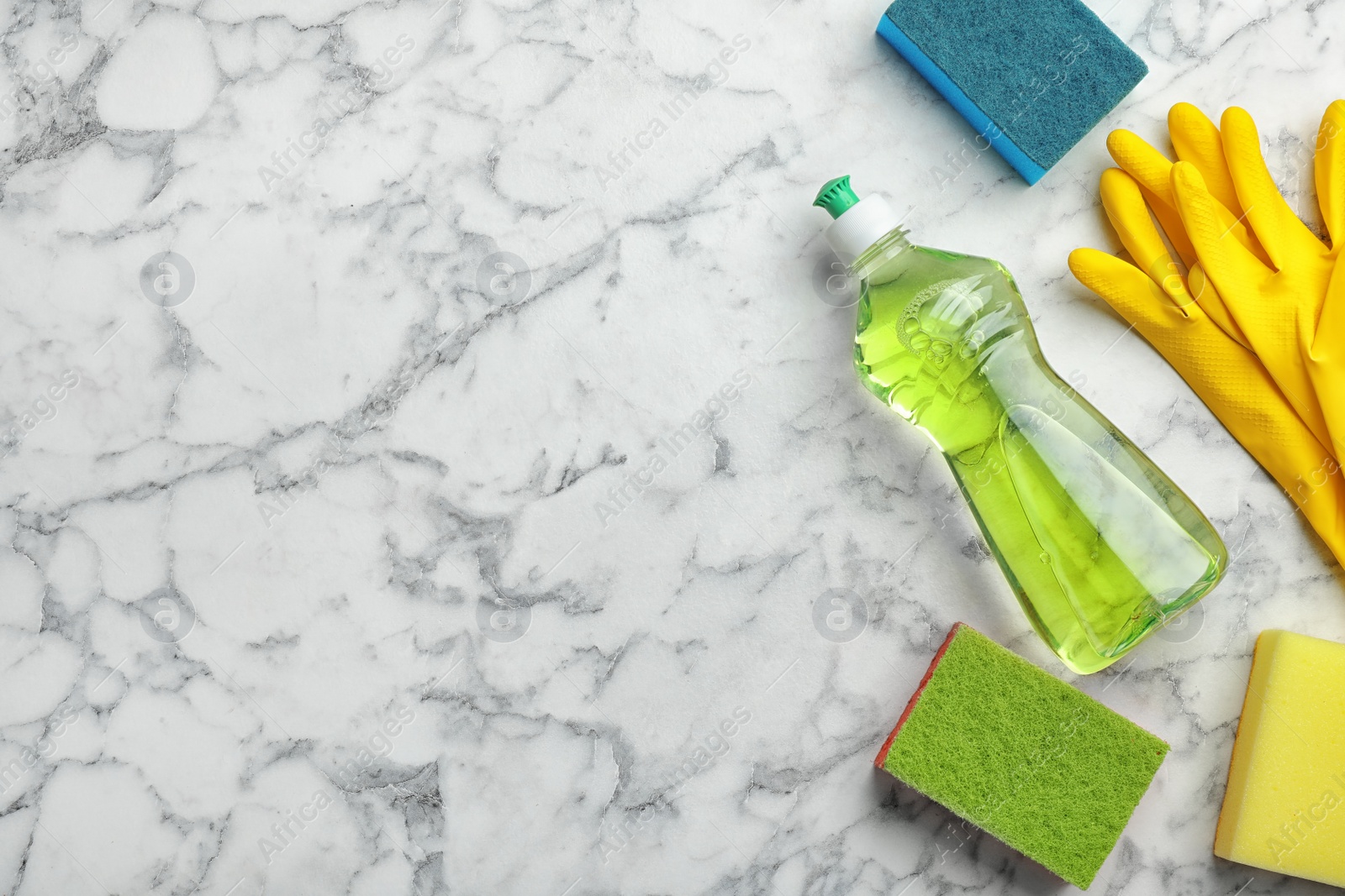 Photo of Flat lay composition with cleaning supplies for dish washing and space for text on marble background