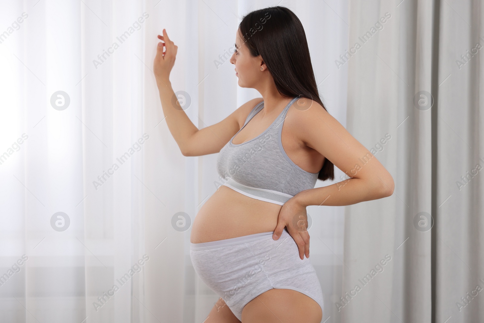 Photo of Beautiful pregnant woman in comfortable maternity underwear indoors