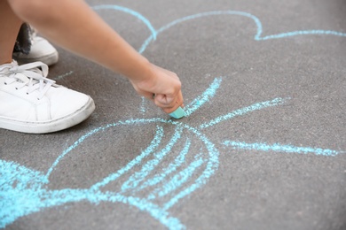 Little child drawing with chalk on asphalt, closeup