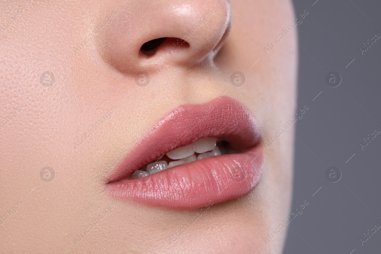 Photo of Woman with beautiful lips on grey background, closeup