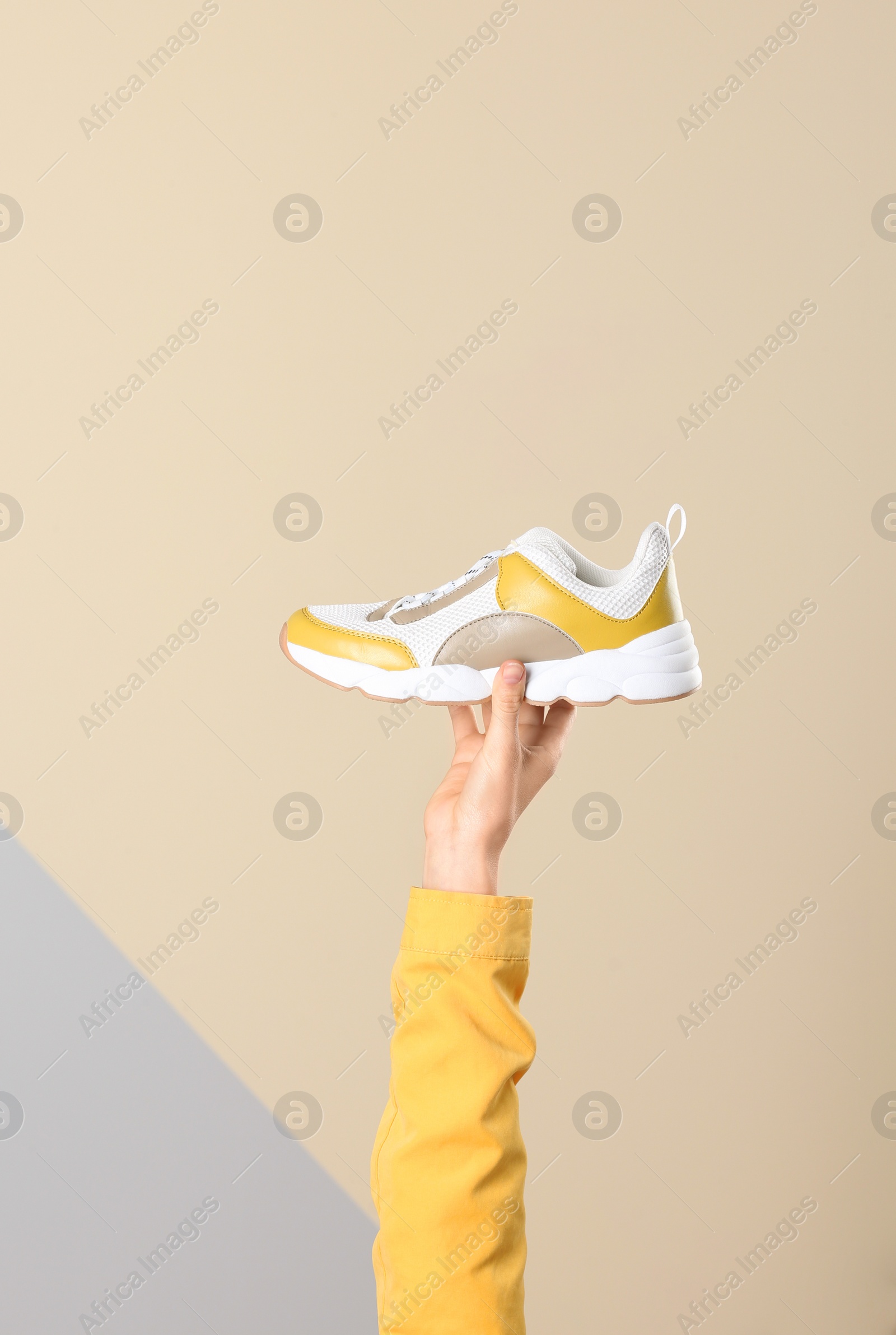 Photo of Woman holding sportive shoe on color background, closeup. Space for text