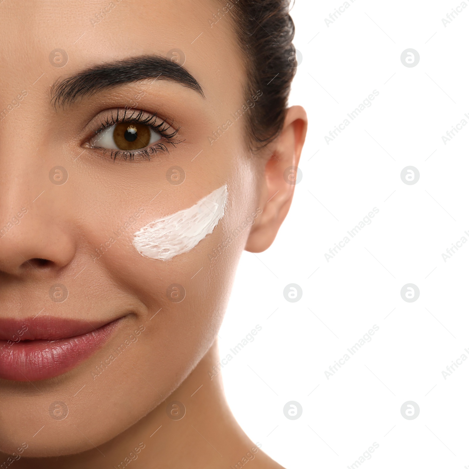 Photo of Young woman with cream on face against white background, closeup