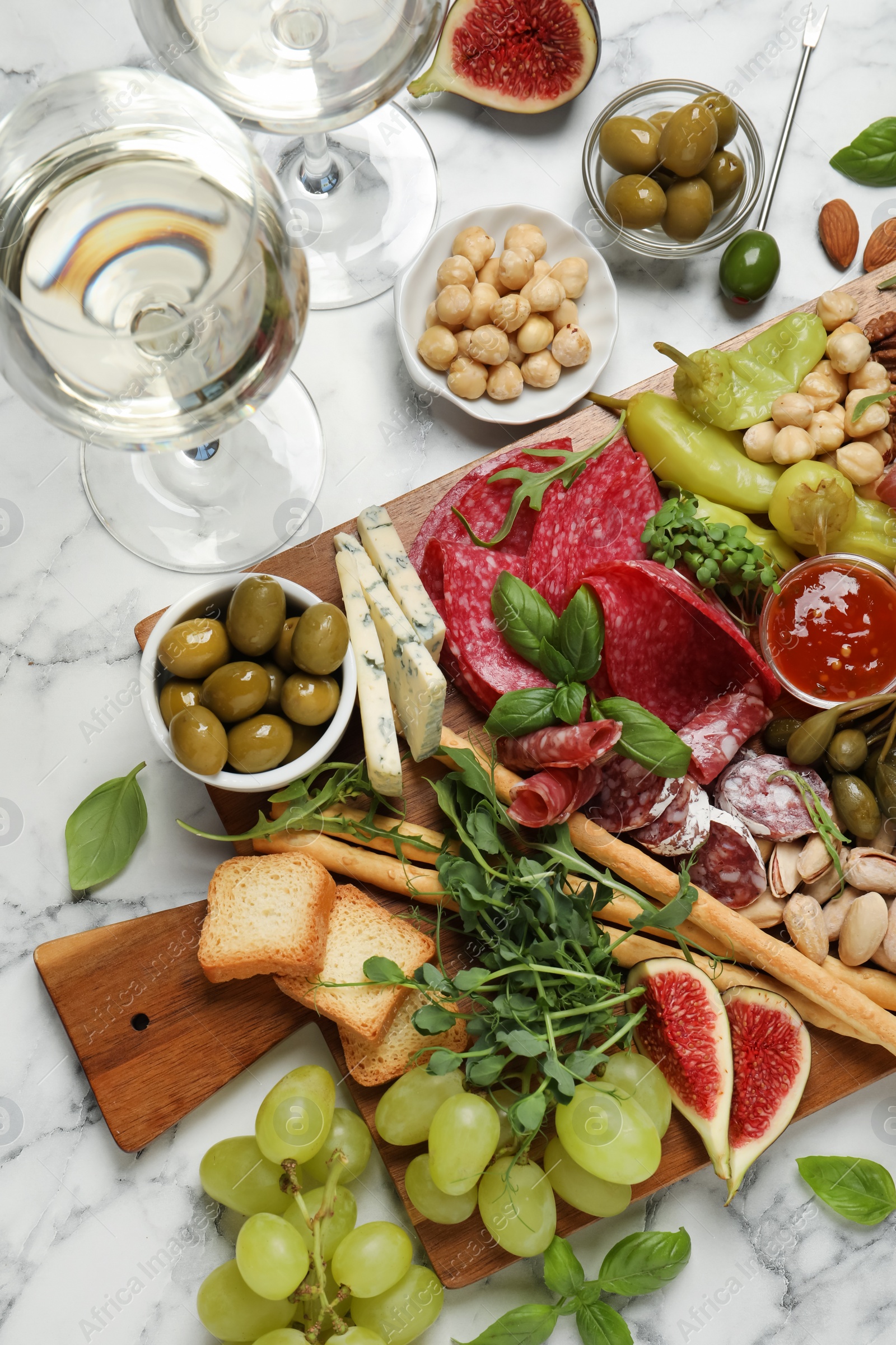 Photo of Set of different delicious appetizers served on white marble table, flat lay