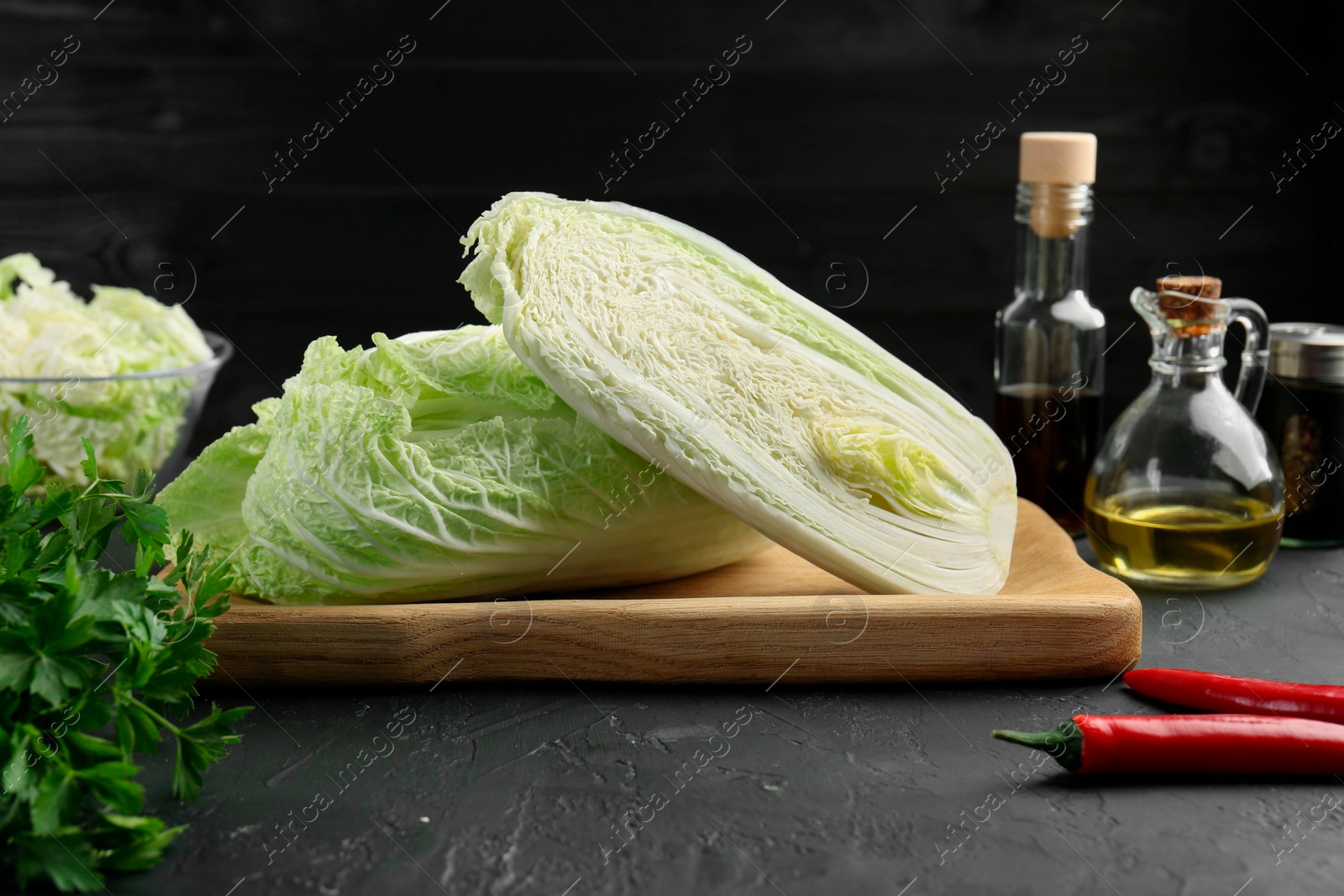 Photo of Fresh Chinese cabbages and other products on black textured table