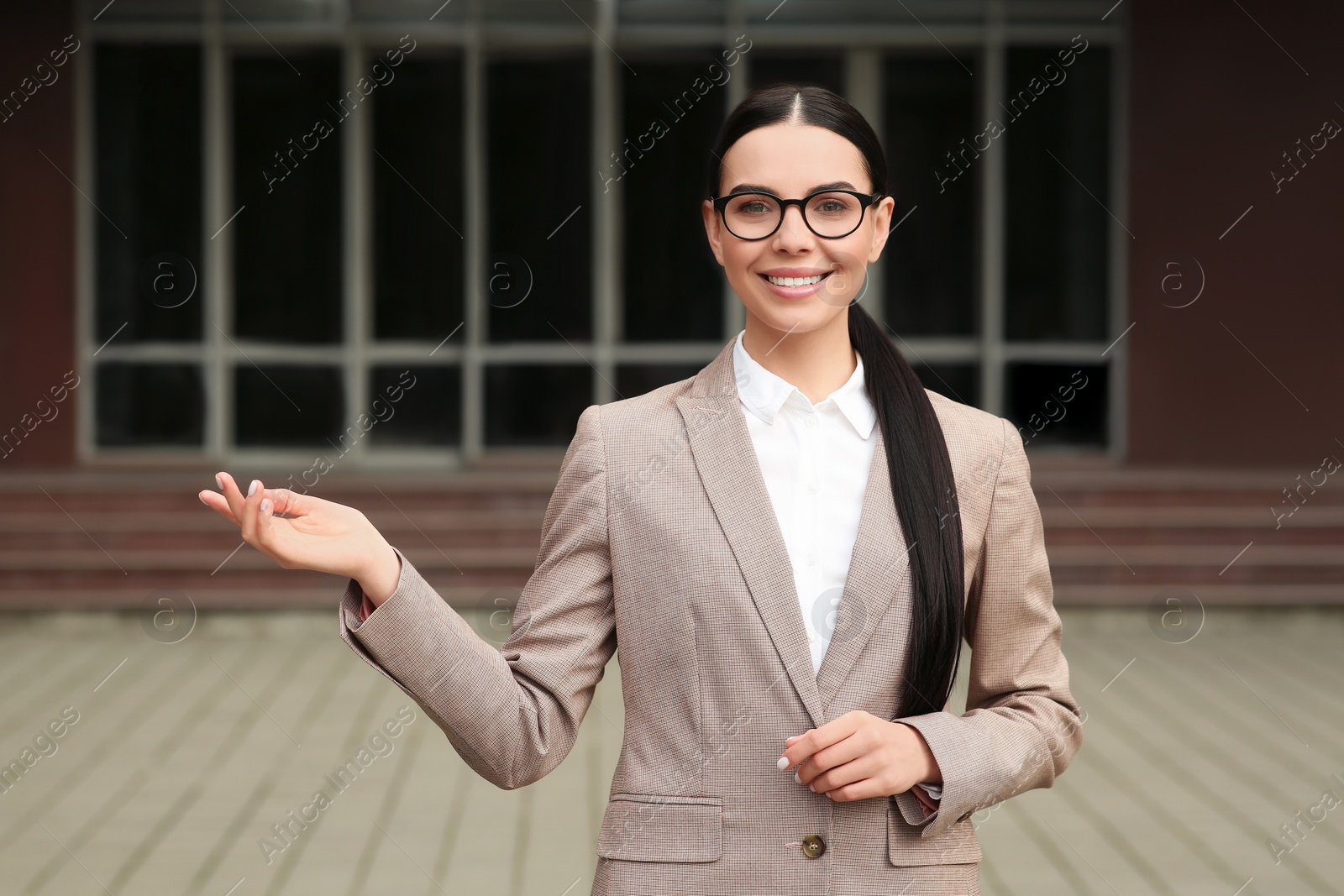 Photo of Beautiful real estate agent in nice suit outdoors, space for text