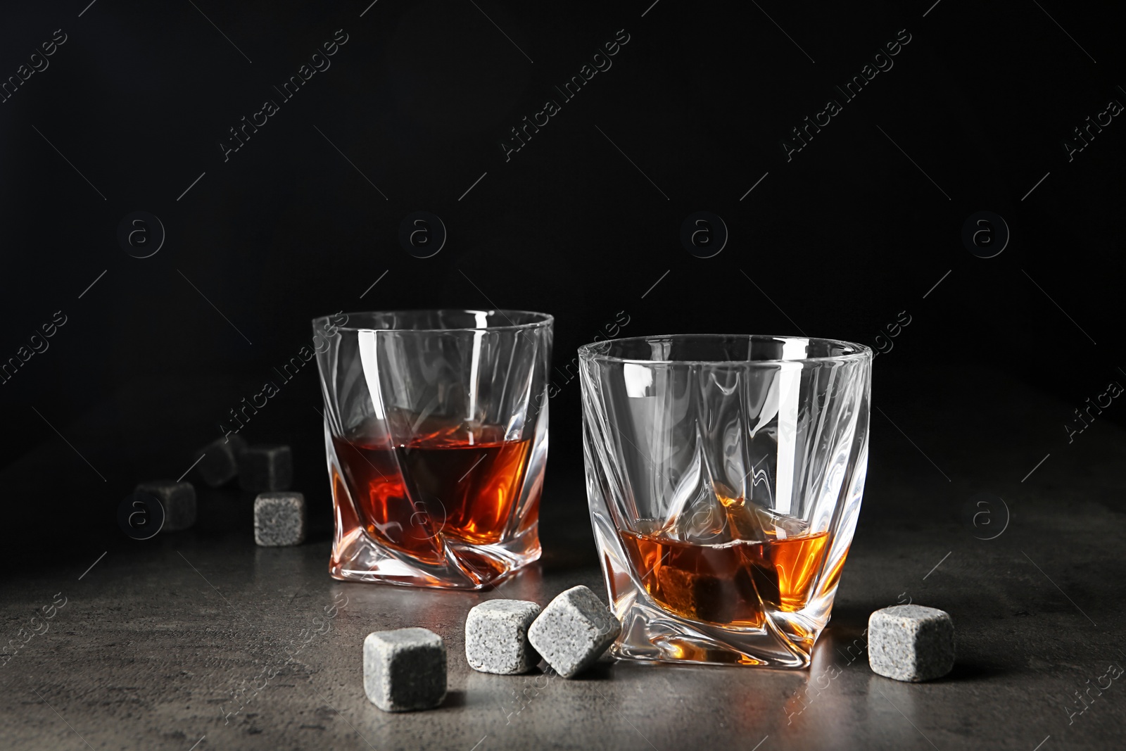 Photo of Glasses with liquor and whiskey stones on table