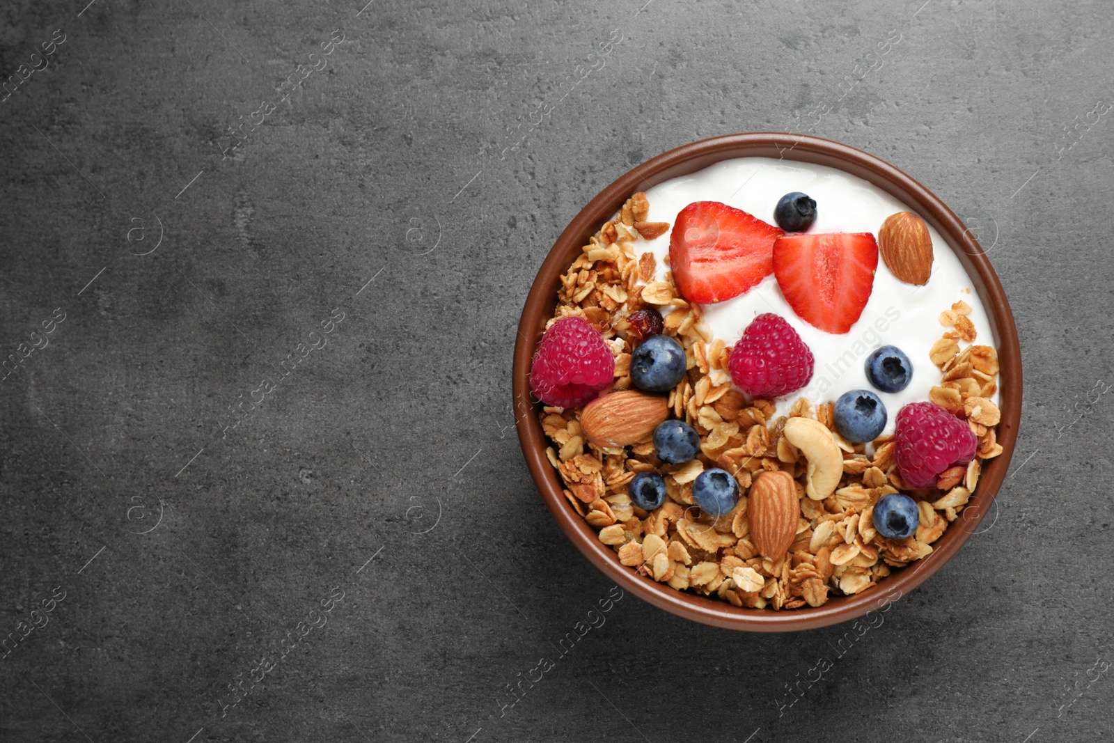 Photo of Tasty homemade granola served on grey table, top view with space for text. Healthy breakfast