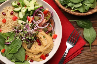 Photo of Delicious vegan bowl with cucumbers, spinach and bulgur on wooden table, flat lay