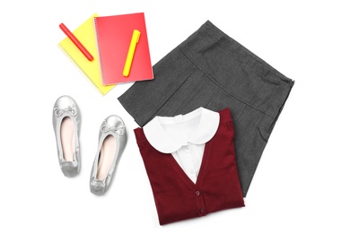 Stylish school uniform and stationery on white background, top view