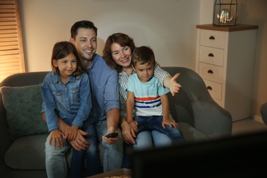 Photo of Family watching TV in room at evening time