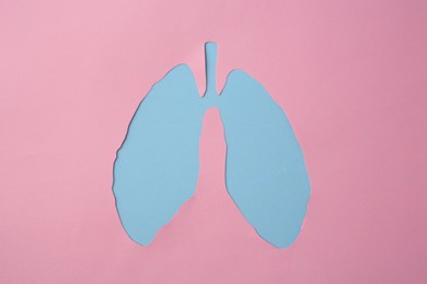 Pink paper with hole in shape of human lungs, top view