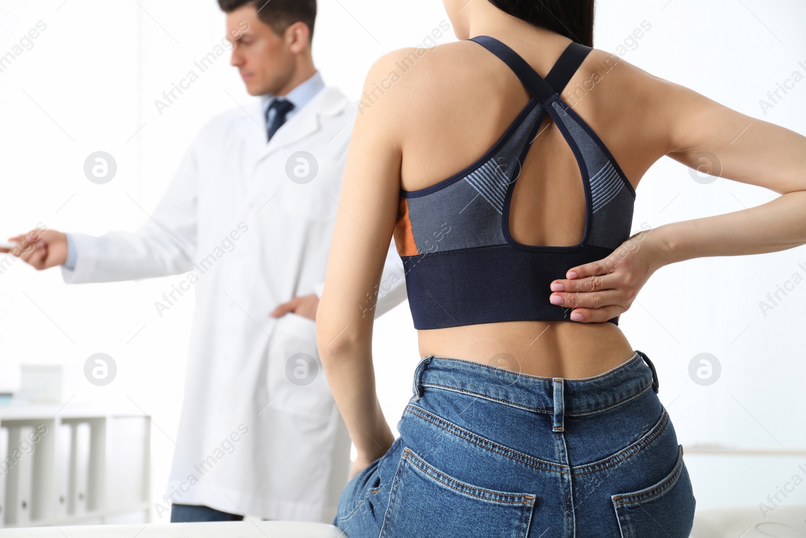 Photo of Young woman visiting orthopedist in medical office, closeup