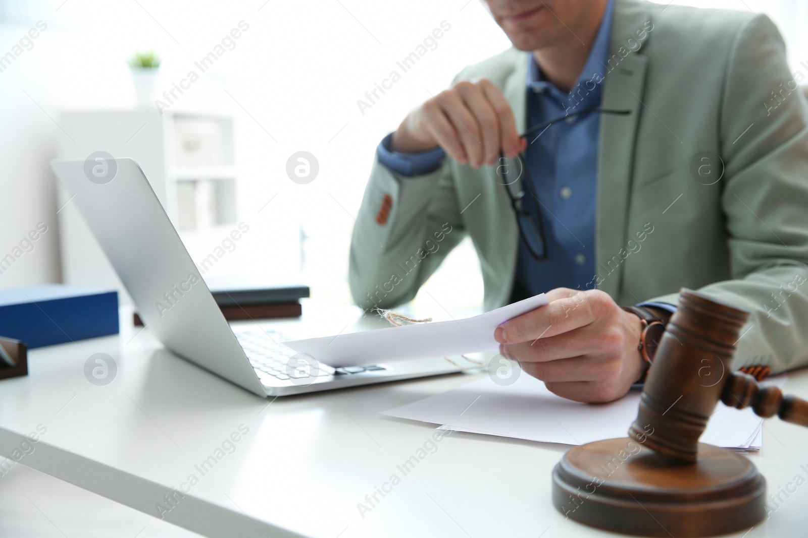 Photo of Notary working at table in office, closeup. Law and justice concept