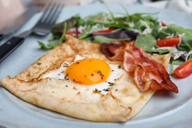 Delicious crepe with egg on plate, closeup. Breton galette