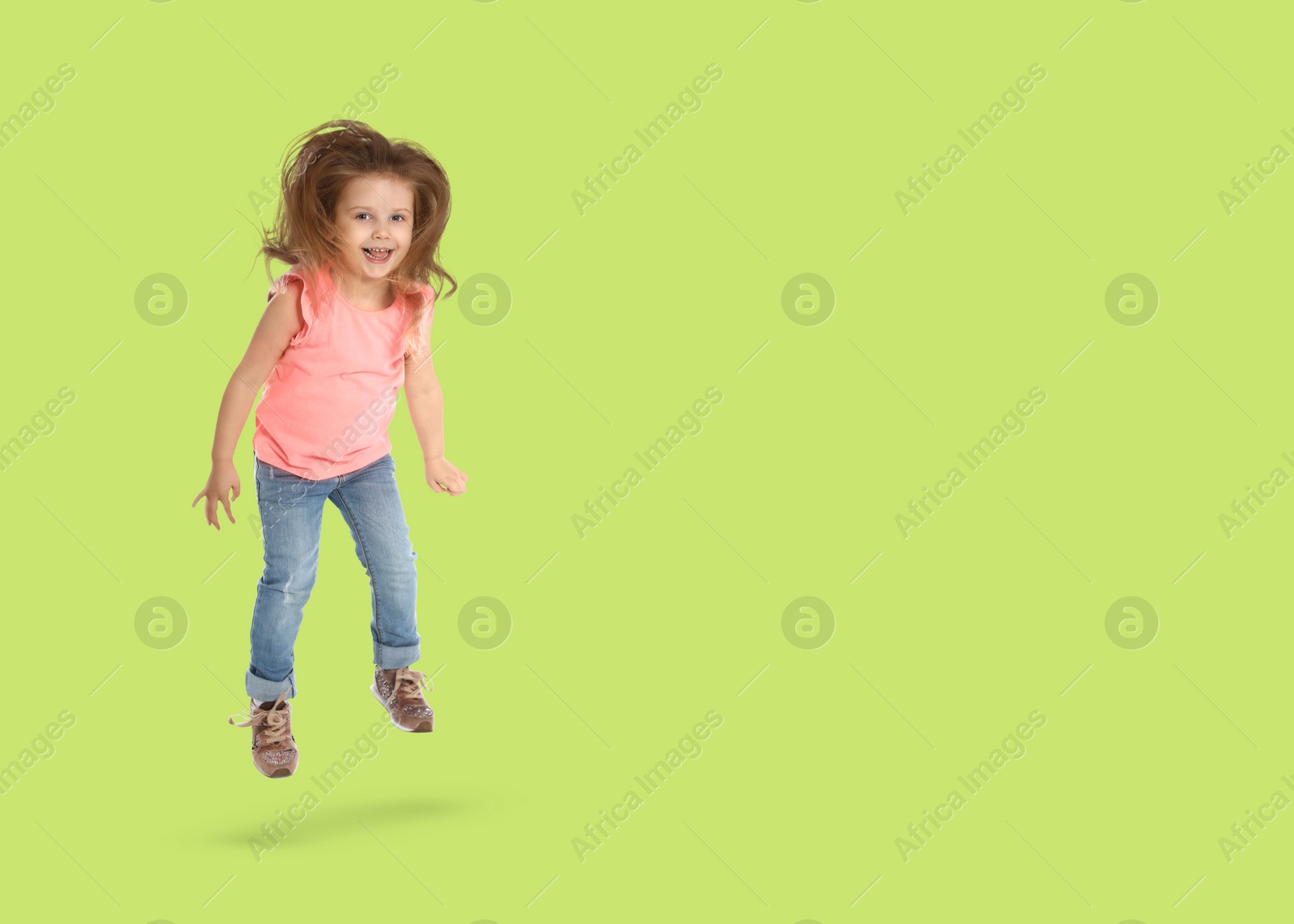 Image of Cute girl jumping on light green background, space for text