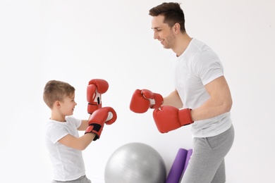 Photo of Happy dad and his son boxing in gym