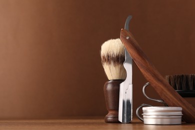 Photo of Moustache and beard styling tools on wooden table. Space for text