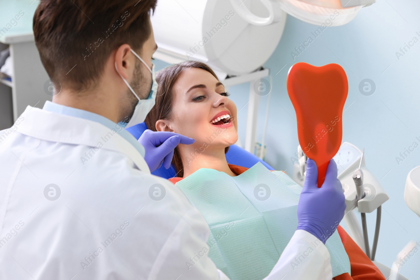 Photo of Professional dentist working with patient in modern clinic