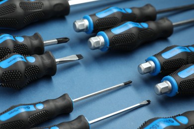 Photo of Set of screwdrivers on blue background, closeup
