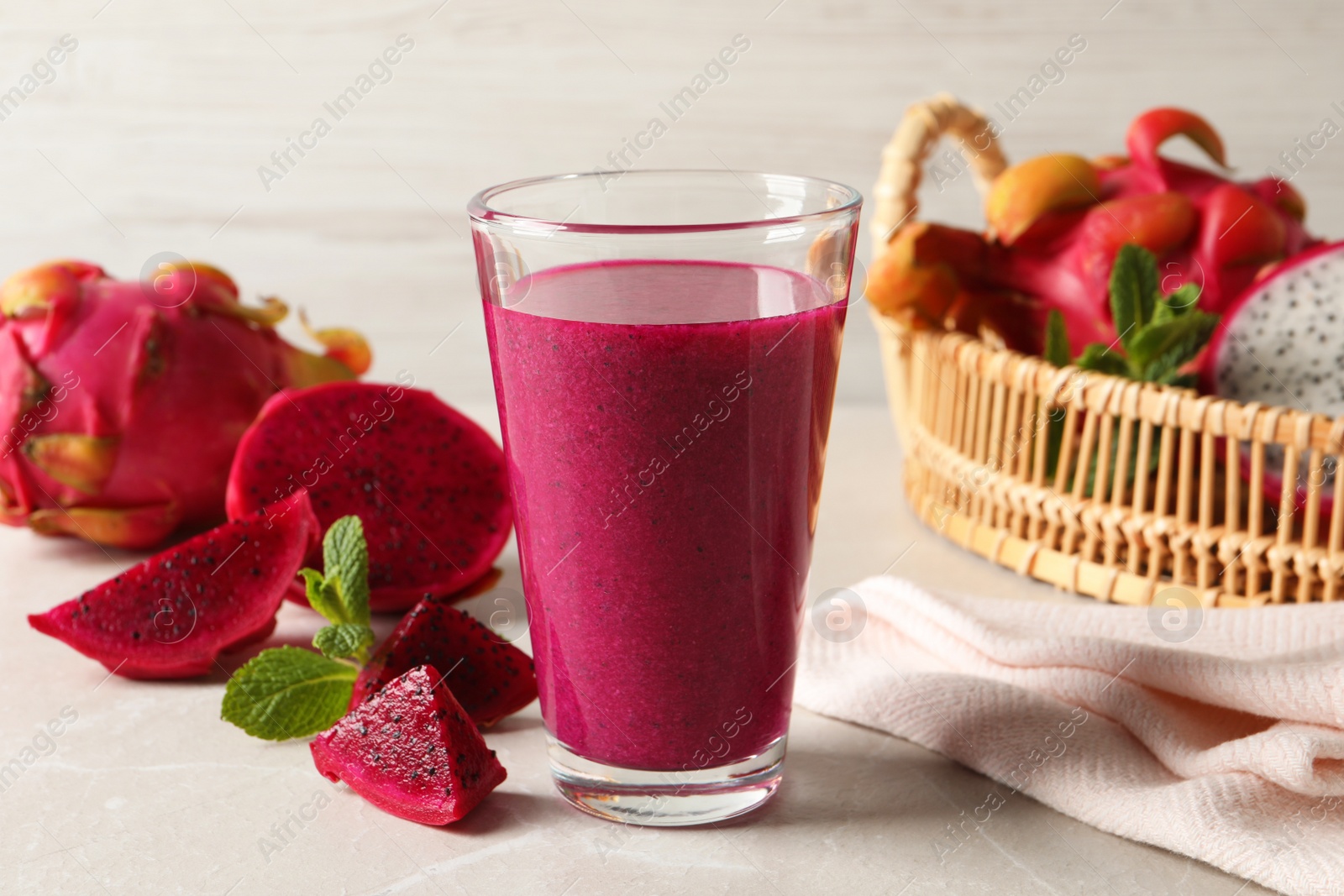 Photo of Delicious pitahaya smoothie and fresh fruits on light grey table