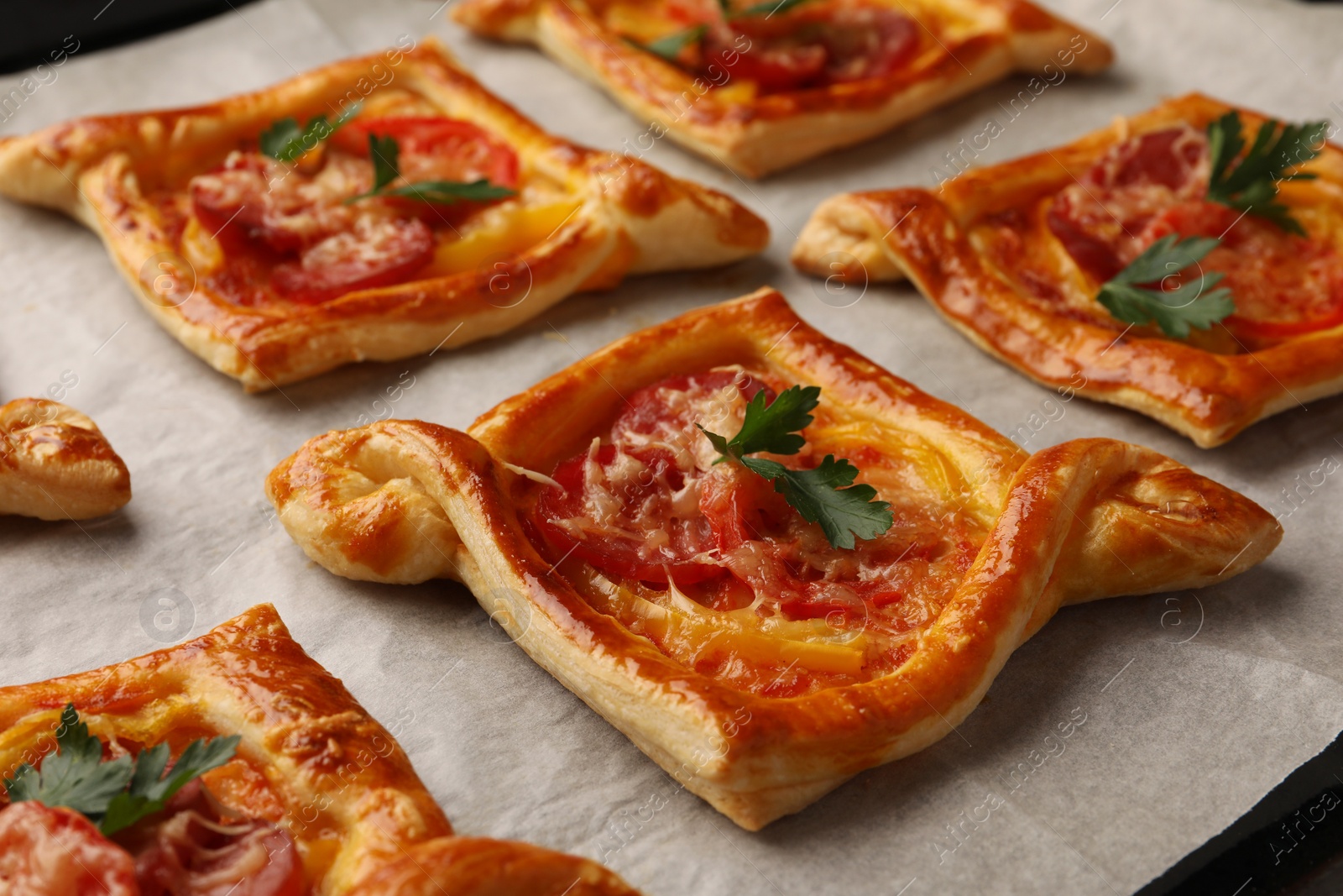 Photo of Fresh delicious puff pastry with tasty filling on baking sheet, closeup