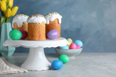 Easter cakes and colorful eggs on light grey table