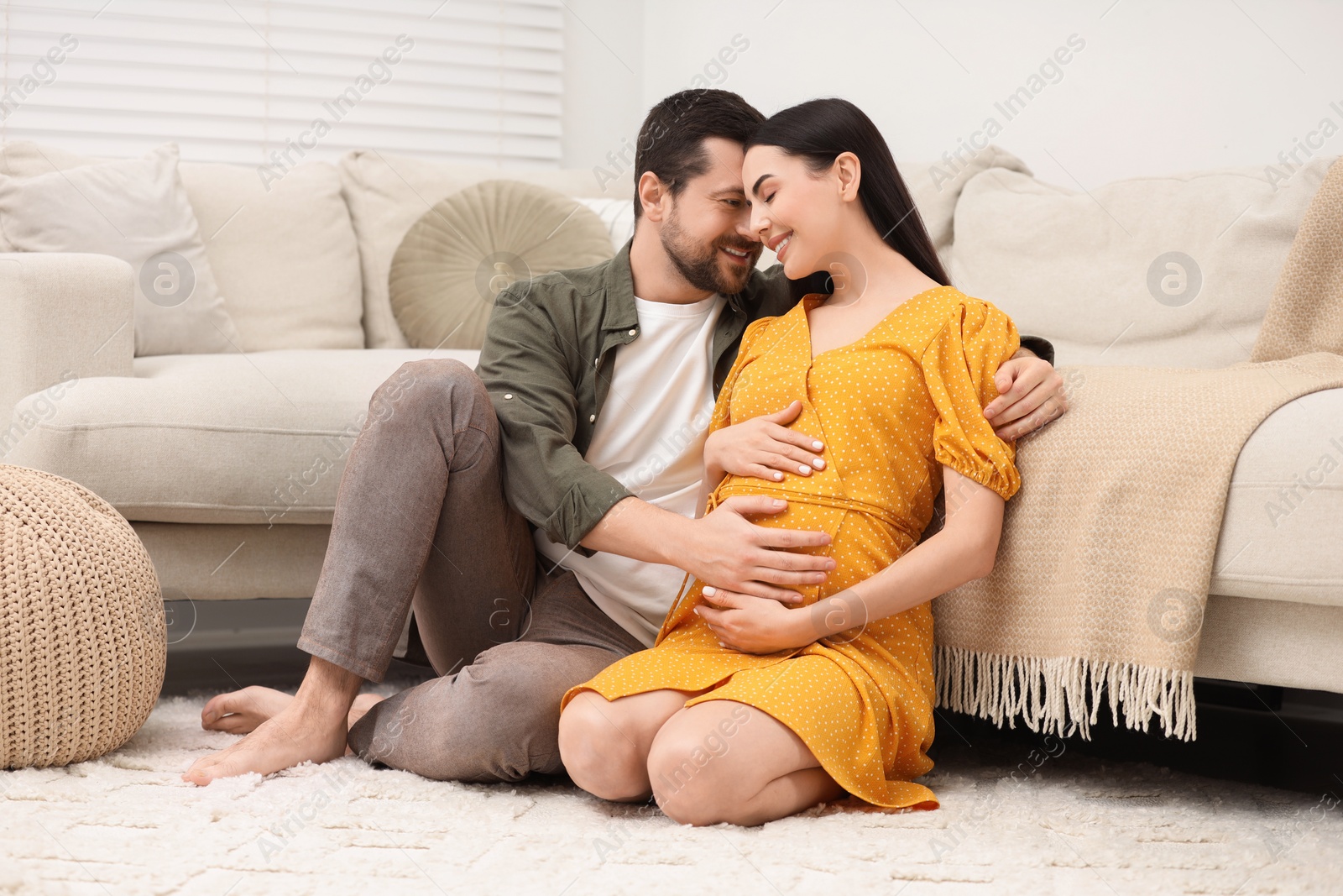 Photo of Happy pregnant woman spending time with her husband at home