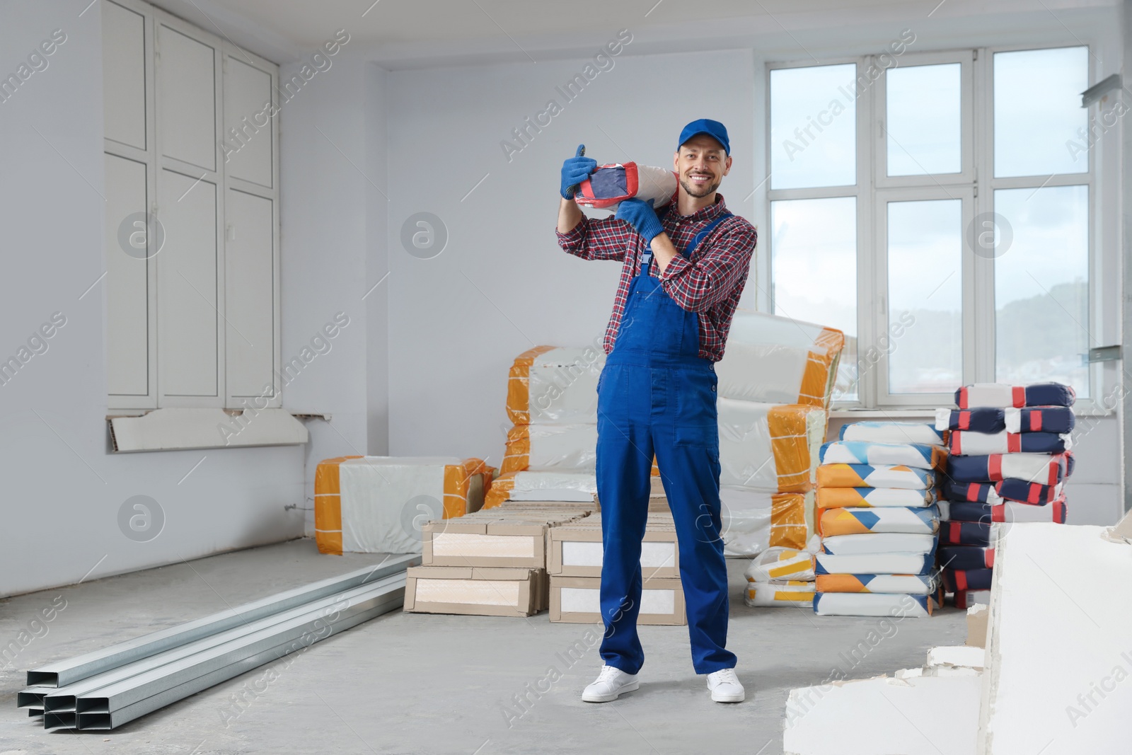 Photo of Construction worker with new building materials in room prepared for renovation