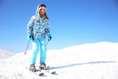 Photo of Young woman skiing outdoors, space for text. Winter vacation