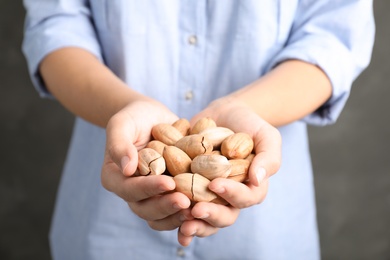 Photo of Woman holding pecan nuts in hands, closeup