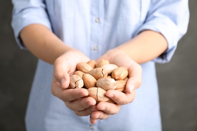 Woman holding pecan nuts in hands, closeup