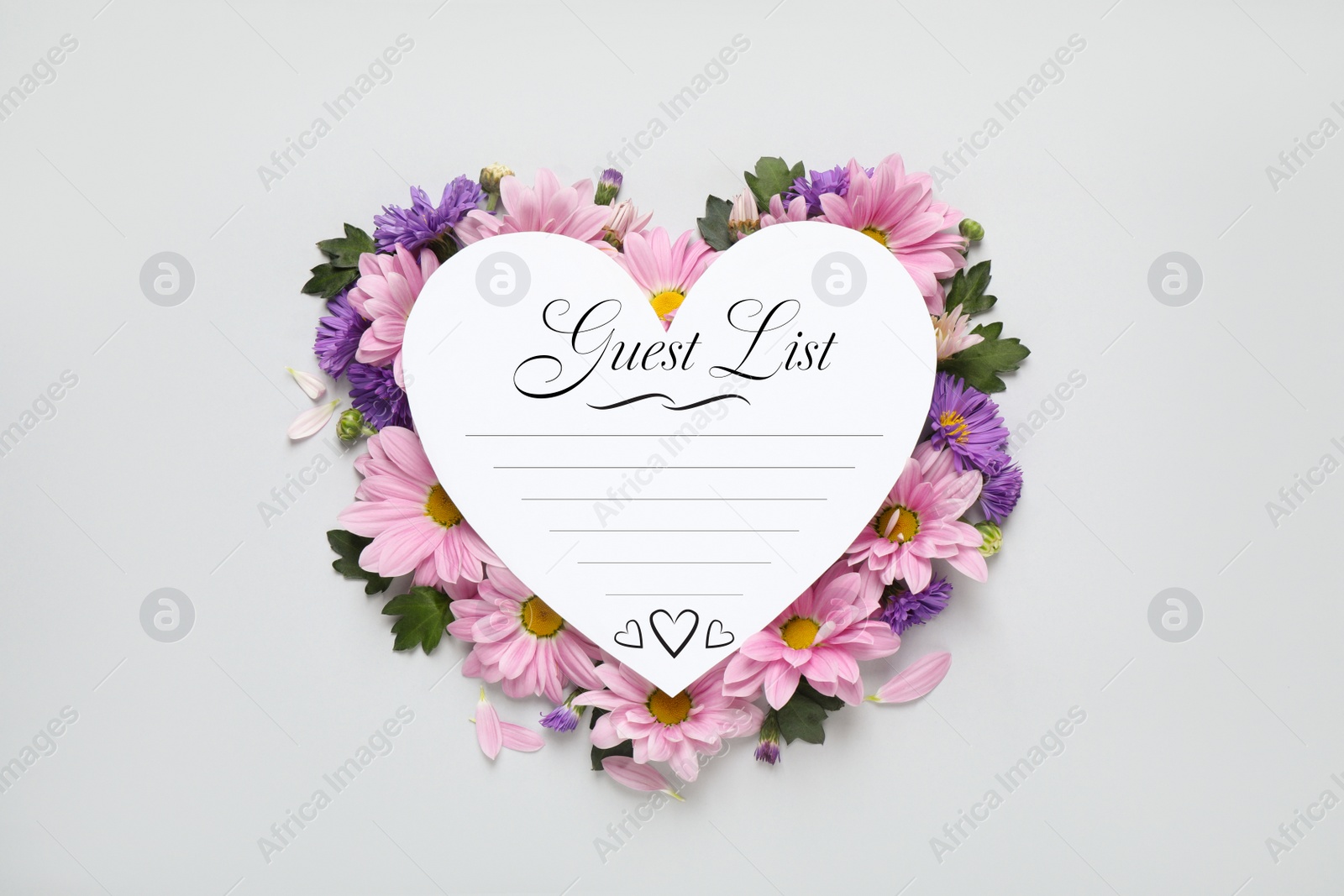 Image of Beautiful flowers and guest list on white background, top view