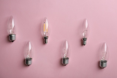 Photo of Vintage and modern lamp bulbs on pink background, flat lay