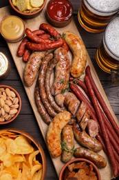 Set of different tasty snacks and beer on wooden table, flat lay