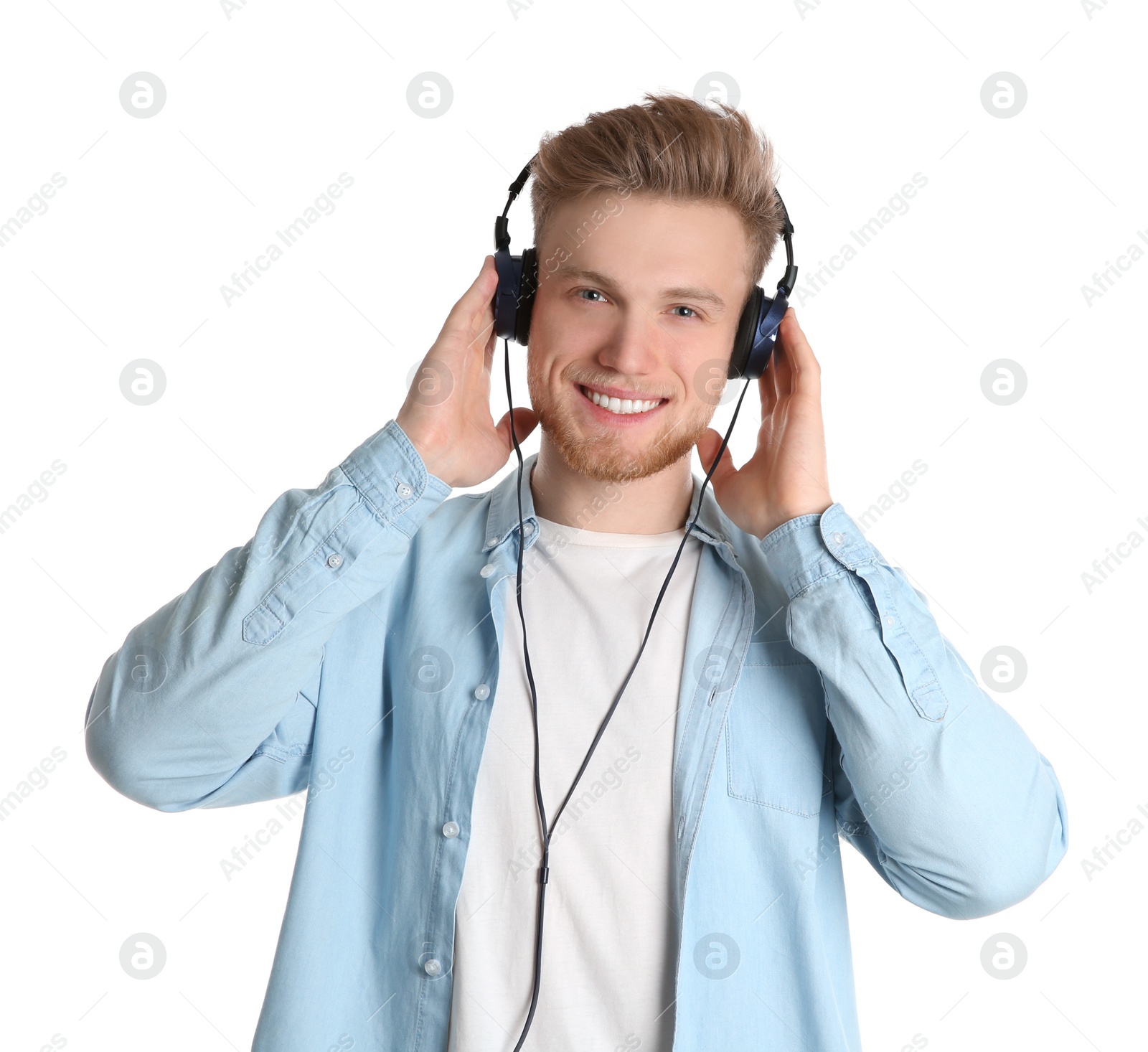 Photo of Handsome young man listening to music with headphones on white background