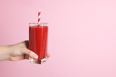 Photo of Woman holding glass of tasty smoothie on pink background, closeup. Space for text