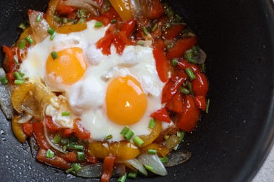 Photo of Cooking tasty eggs with vegetables in frying pan, closeup