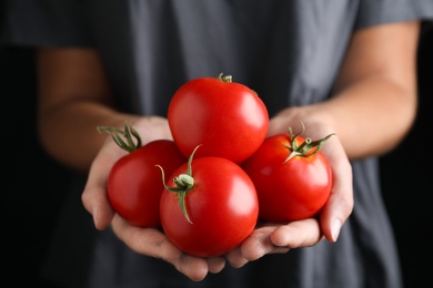 Photo of Farmer holding fresh ripe tomatoes, closeup view