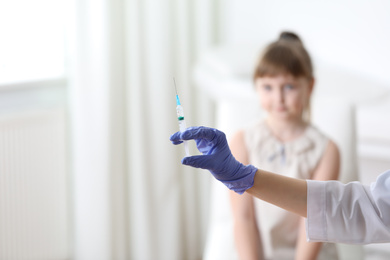 Photo of Doctor holding syringe with chickenpox vaccine for child in clinic, closeup. Varicella virus prevention