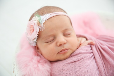 Photo of Adorable newborn girl lying in baby nest, closeup