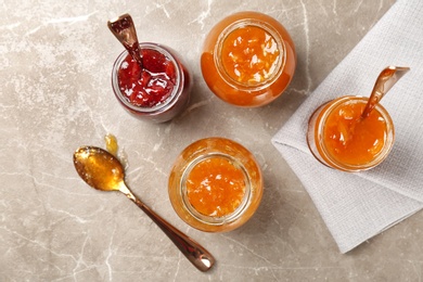 Photo of Jars with different sweet jam on table