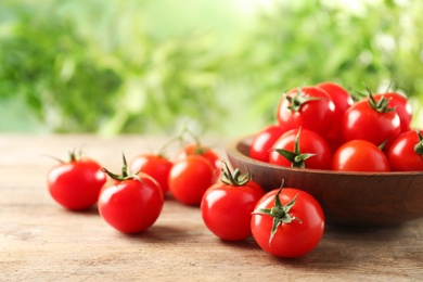 Photo of Bowl of fresh cherry tomatoes on wooden table