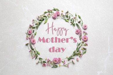 Happy Mother's Day. Greeting card with frame of pink flowers on light background, top view