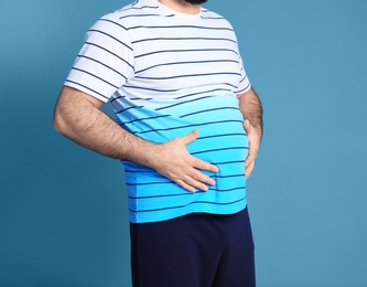 Overweight man on color background