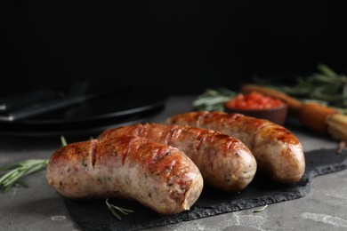 Photo of Tasty grilled sausages served on grey table