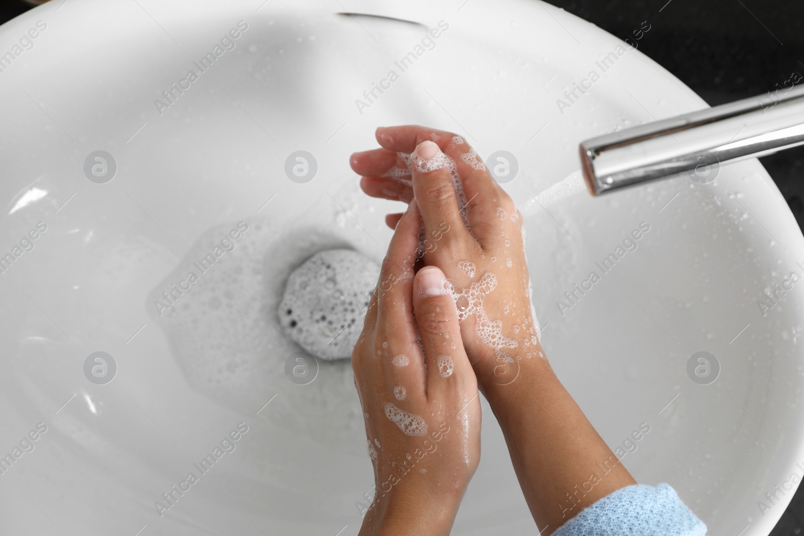 Photo of Woman washing hands with soap over sink in bathroom, top view. Space for text