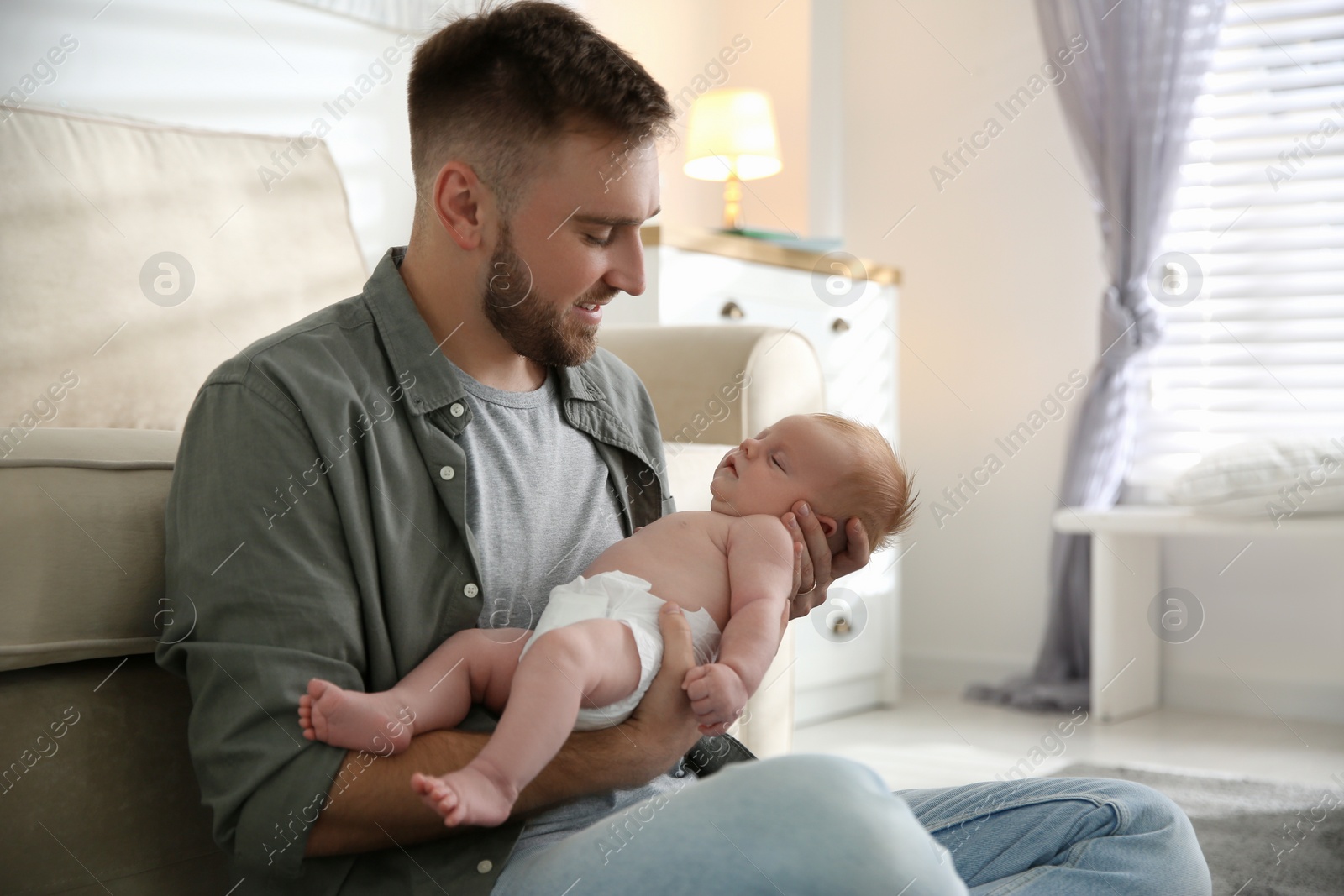 Photo of Father with his newborn son at home